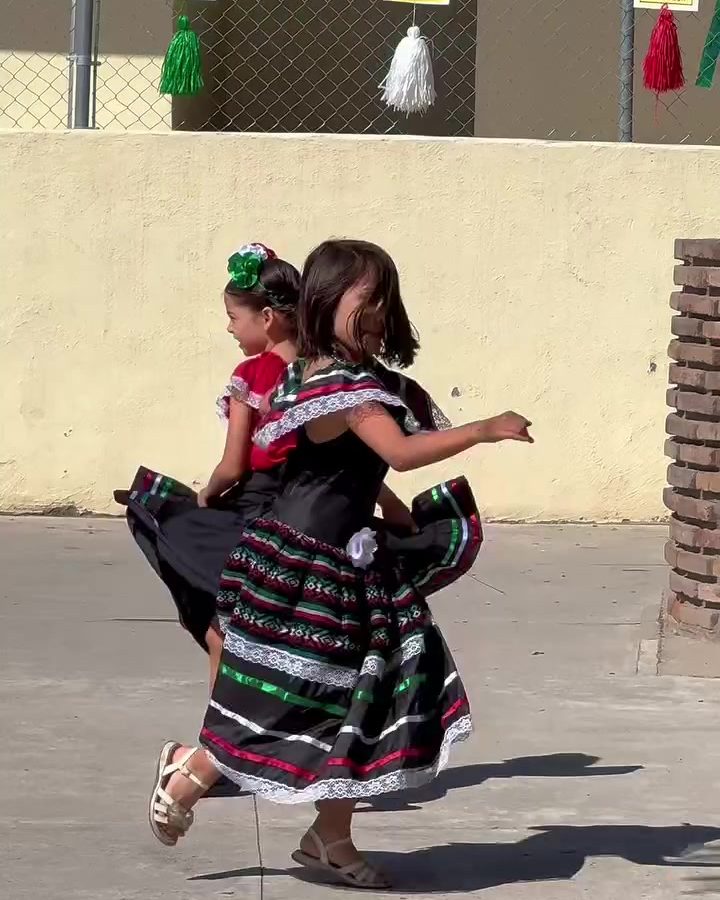 Pareja de alumnos bailando música regional mexicana en el patio