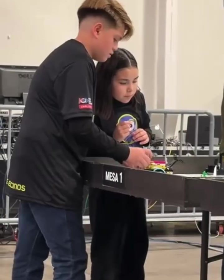 Dos alumnos de sexto grado de Colegio Encinos programando su robot LEGO en la mesa de competencia del FIRST LEGO League