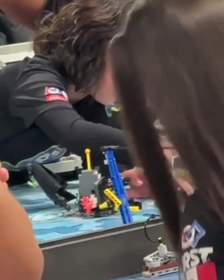 Alumnos de Colegio Encinos alrededor del tablero de la competencia de robótica
