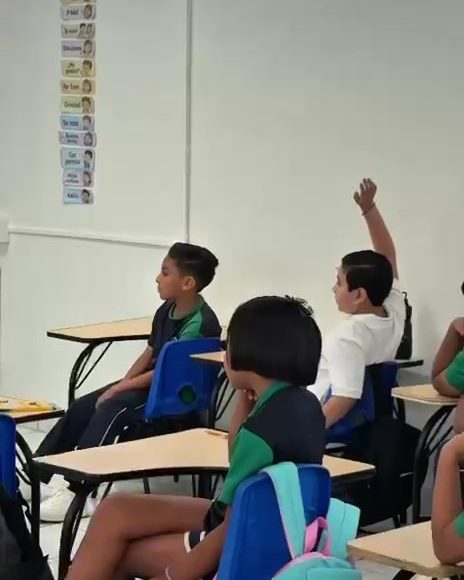 Alumnos de primaria levantando la mano para participar en clase